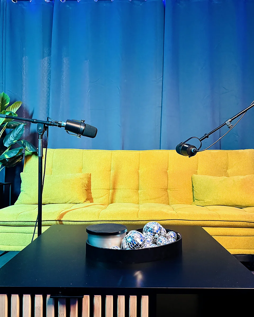 Gelbes Sofa mit zwei Mikrofonen im C90 Studio