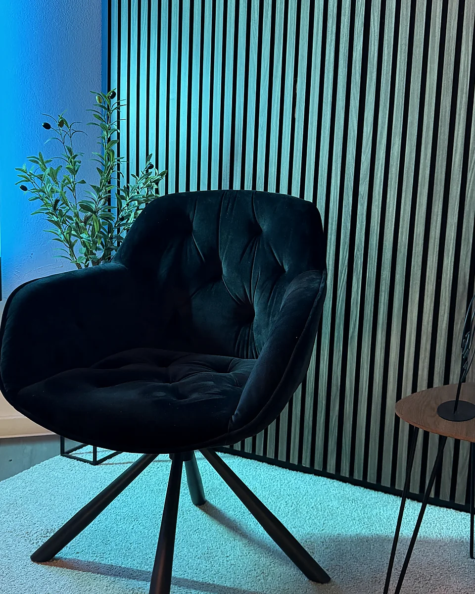 Dunkler Studiosessel vor Akustiklamellen